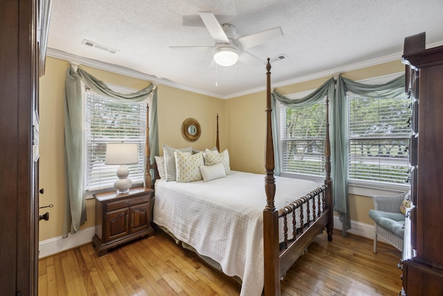 647 Ellis St, Mount Pleasant, SC 29464 - bedroom featuring ornamental molding, light wood-type flooring, a textured ceiling, baseboards, and ceiling fan