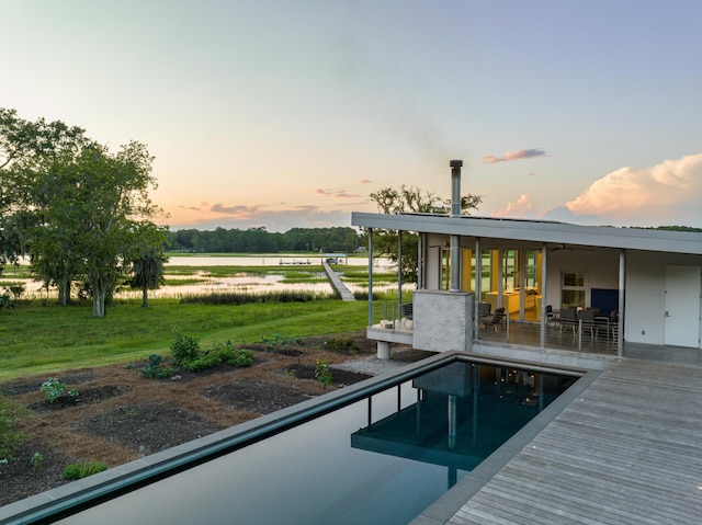 pool at dusk with a lawn