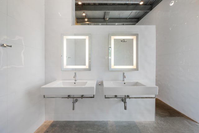 bathroom with concrete flooring and tile walls