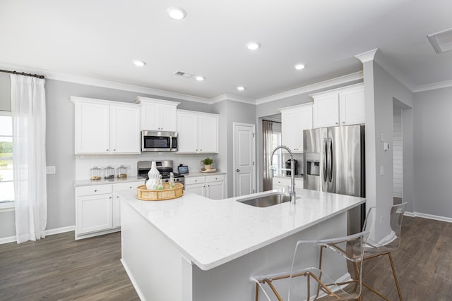 kitchen featuring a kitchen island with sink, dark wood-type flooring, sink, appliances with stainless steel finishes, and white cabinetry