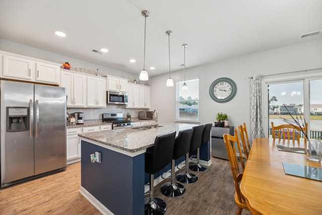 9711 Fanning Basket Ln, Ladson, SC 29456 - kitchen with stainless steel appliances, light wood finished floors, white cabinetry, and recessed lighting