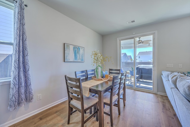 dining space with visible vents, baseboards, and wood finished floors