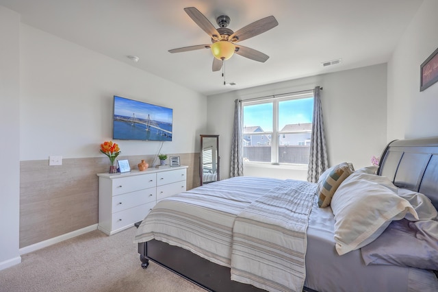 bedroom featuring light carpet, ceiling fan, visible vents, and baseboards