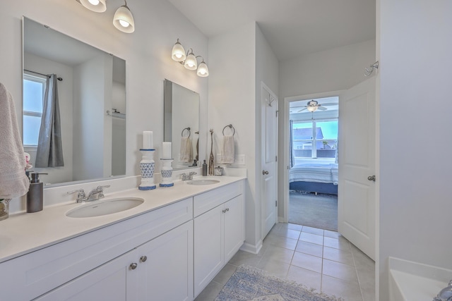 ensuite bathroom with double vanity, ensuite bath, a sink, and tile patterned floors