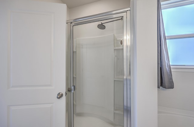 bathroom with a washtub and a stall shower