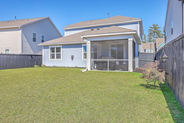 back of property featuring a sunroom, a fenced backyard, a lawn, and roof with shingles