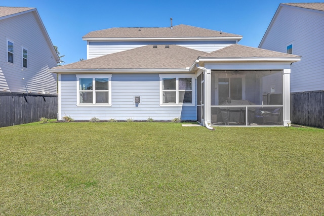 rear view of house featuring a sunroom, a fenced backyard, a shingled roof, and a yard