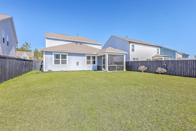 back of house with a lawn, a fenced backyard, and a sunroom