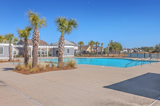 pool with a patio area and fence