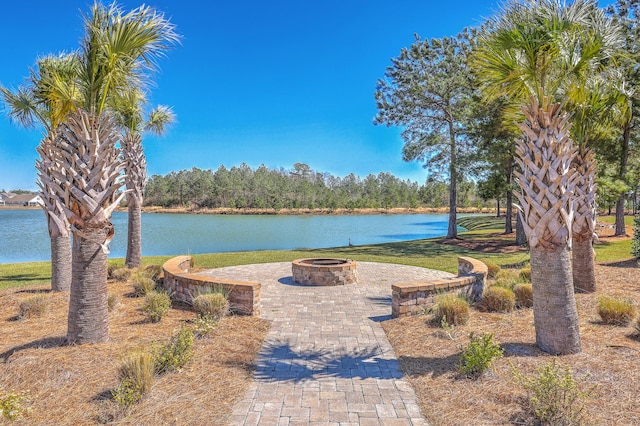 view of home's community featuring a fire pit, a patio, a lawn, and a water view