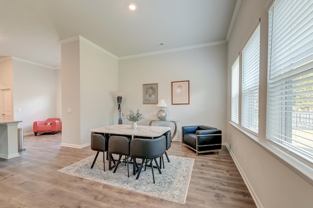 dining area featuring crown molding and light hardwood / wood-style flooring