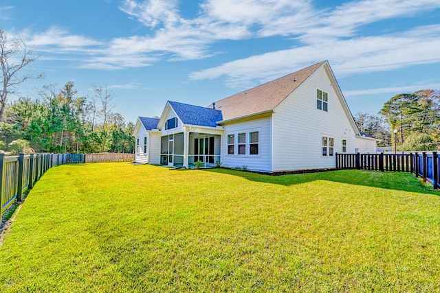 back of property featuring a sunroom and a yard