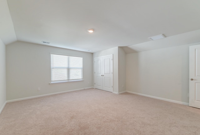 additional living space with lofted ceiling and light carpet