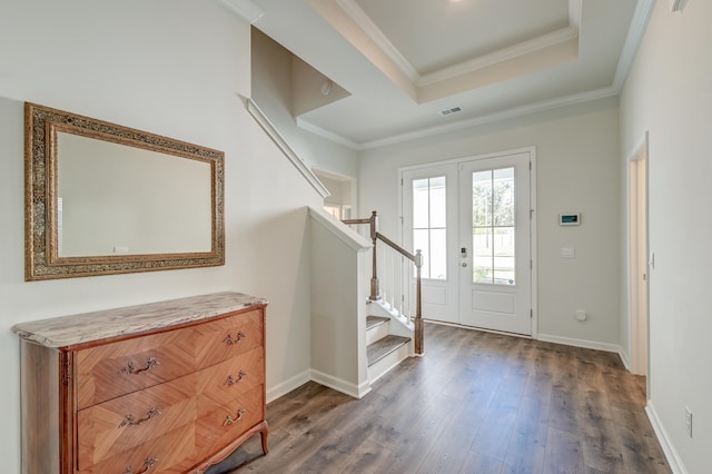 entryway with dark hardwood / wood-style flooring, ornamental molding, a tray ceiling, and french doors