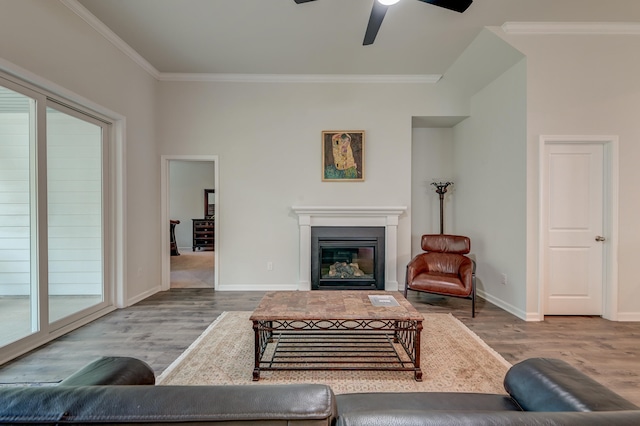 living room featuring ceiling fan, wood-type flooring, and crown molding