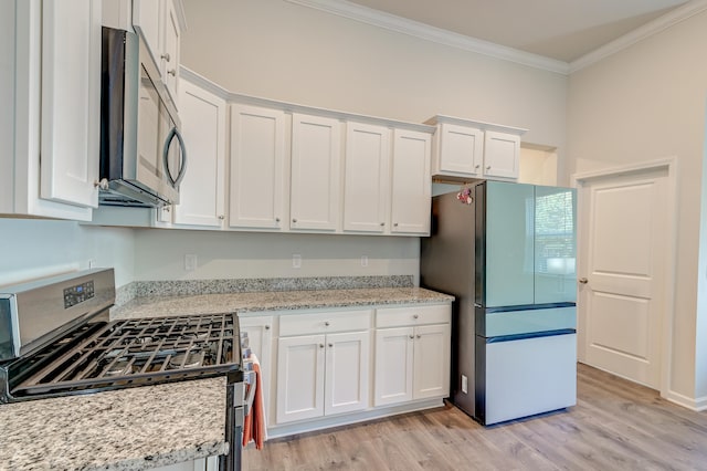 kitchen with crown molding, light wood-type flooring, light stone counters, white cabinetry, and stainless steel appliances