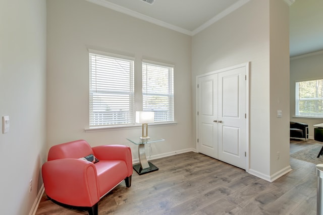 sitting room with light hardwood / wood-style floors, plenty of natural light, and ornamental molding