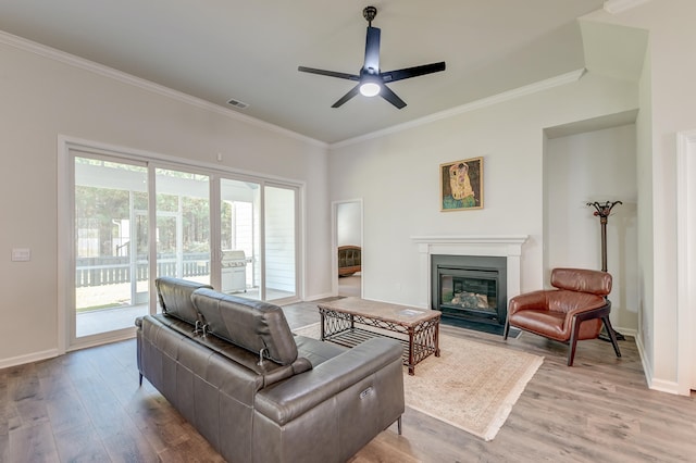 living room featuring ceiling fan, light hardwood / wood-style floors, and ornamental molding