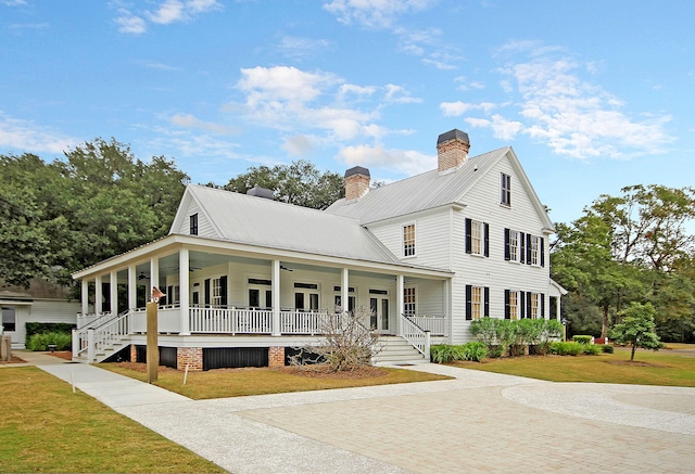 country-style home with covered porch, french doors, a front lawn, and ceiling fan