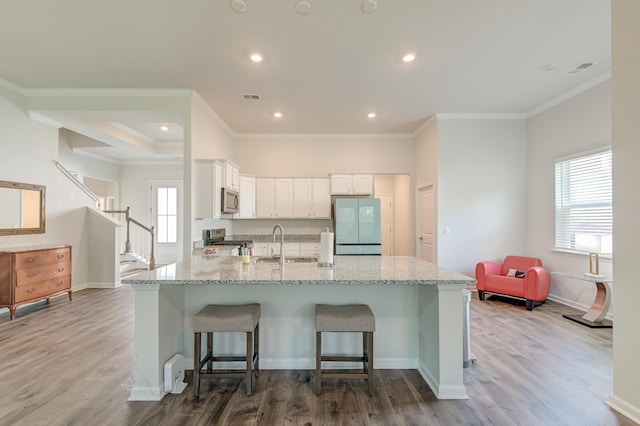 kitchen with white cabinetry, sink, stainless steel appliances, and light hardwood / wood-style floors