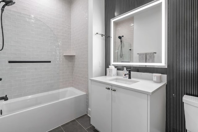 full bathroom featuring tile patterned flooring, tiled shower / bath combo, toilet, and vanity