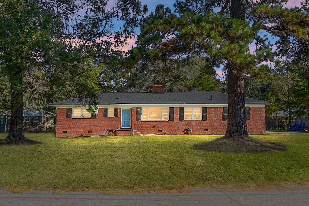 ranch-style home featuring a yard