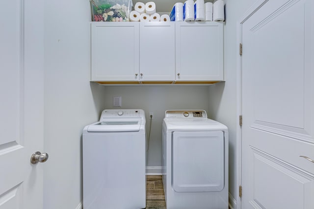 laundry area with independent washer and dryer, cabinets, and hardwood / wood-style floors