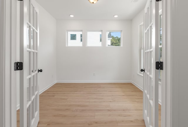 empty room with light hardwood / wood-style flooring and french doors