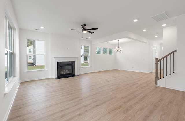 unfurnished living room featuring light hardwood / wood-style floors and ceiling fan with notable chandelier