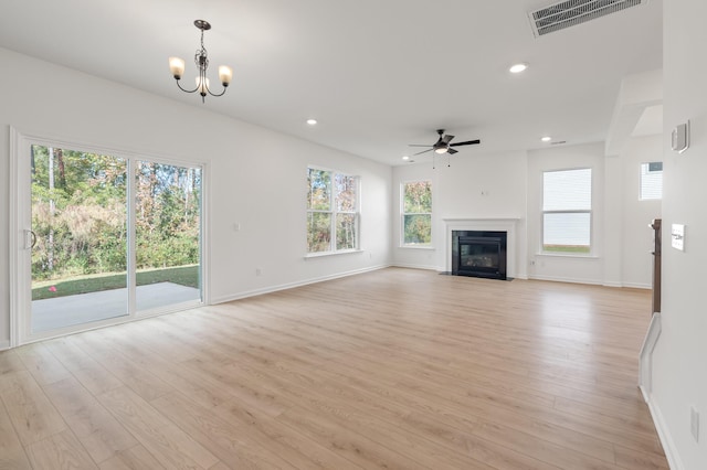 unfurnished living room featuring light hardwood / wood-style flooring and ceiling fan with notable chandelier