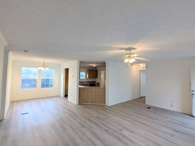 unfurnished living room with light wood-style floors, a textured ceiling, and ceiling fan with notable chandelier