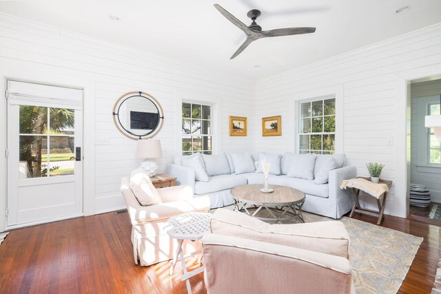 living room featuring dark wood-type flooring and ceiling fan