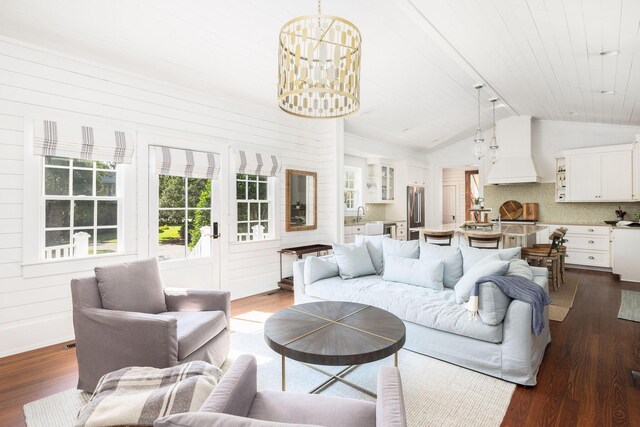 living room featuring french doors, lofted ceiling, an inviting chandelier, dark hardwood / wood-style floors, and sink