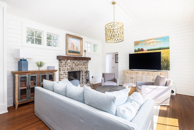 living room featuring vaulted ceiling, an inviting chandelier, dark hardwood / wood-style flooring, a fireplace, and wood walls