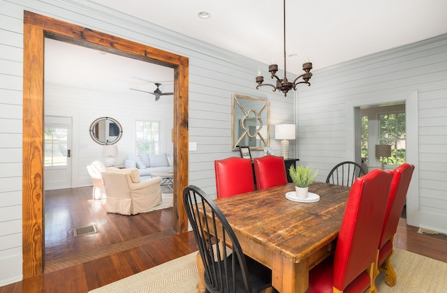 dining area featuring hardwood / wood-style flooring, a wealth of natural light, and a chandelier