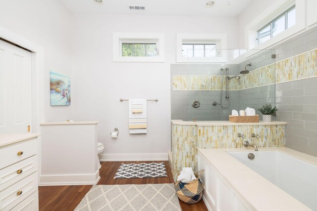 bathroom featuring a healthy amount of sunlight, hardwood / wood-style flooring, and toilet