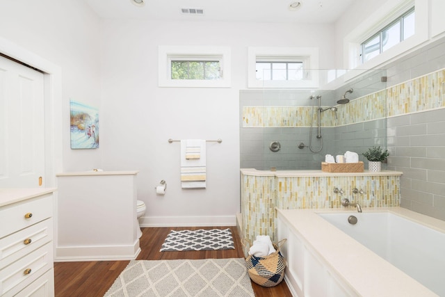 bathroom with hardwood / wood-style flooring, plus walk in shower, and toilet