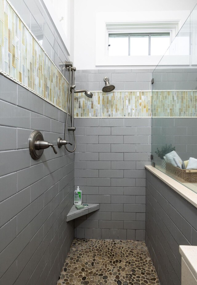 bathroom with tiled shower and a wealth of natural light