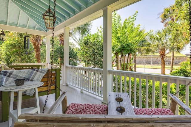 wooden terrace featuring a porch and a gazebo