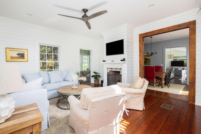 living room featuring ornamental molding, a brick fireplace, dark hardwood / wood-style floors, and ceiling fan