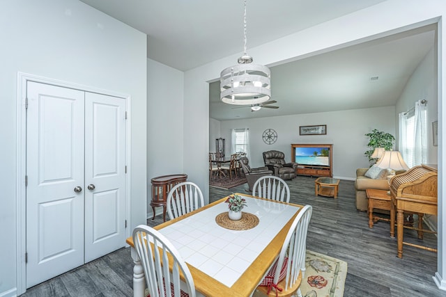 dining room with baseboards, a ceiling fan, and dark wood-style flooring