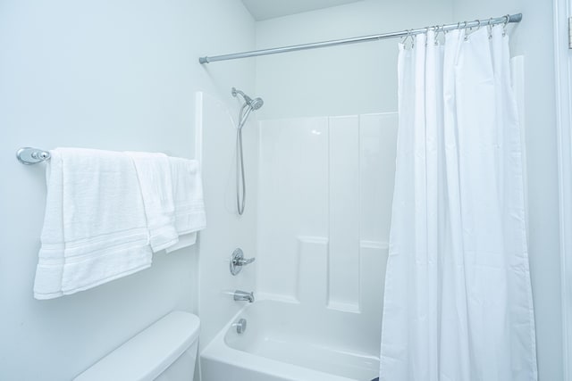 bathroom featuring shower / bath combo with shower curtain and toilet