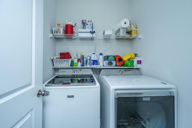 clothes washing area with separate washer and dryer and laundry area