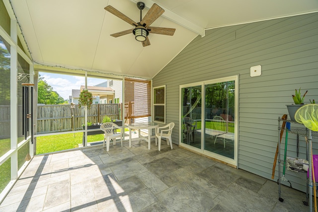 sunroom / solarium with a ceiling fan and beam ceiling