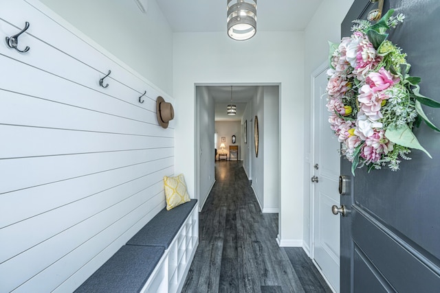 hall featuring dark wood-style flooring and baseboards