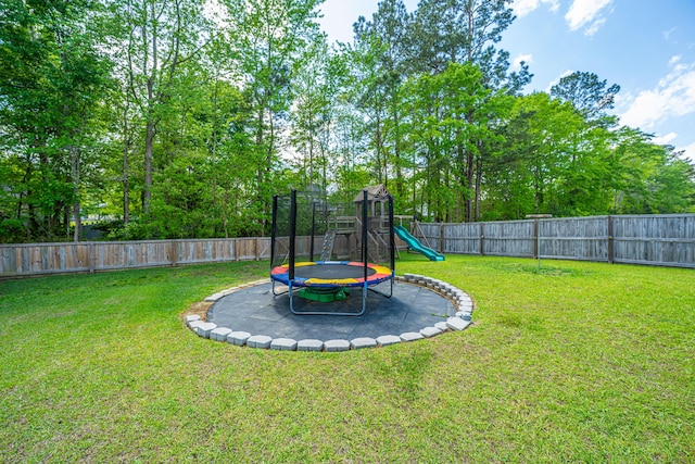 view of yard with a playground, a fenced backyard, and a trampoline