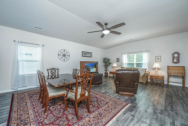 dining area featuring ceiling fan, vaulted ceiling, dark wood-type flooring, and visible vents