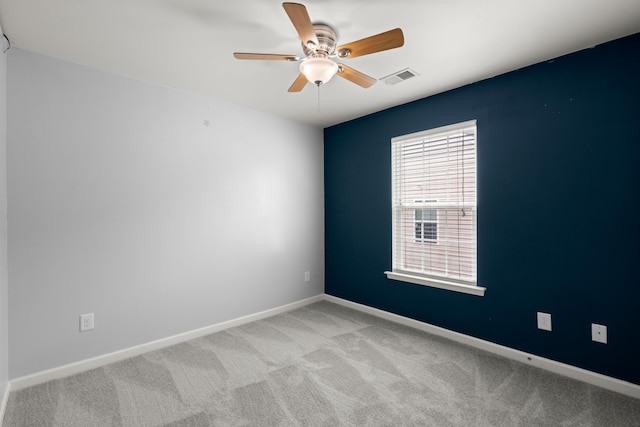 unfurnished room with baseboards, visible vents, light colored carpet, and ceiling fan