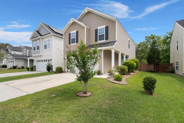 traditional-style house featuring a garage, driveway, a front yard, and fence