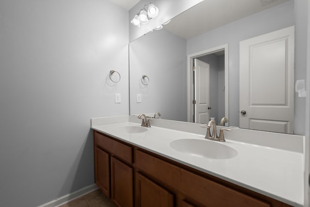 bathroom with tile patterned floors, baseboards, a sink, and double vanity